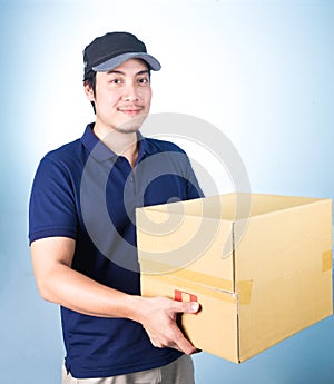 Smiling handsome asian delivery man giving and carrying parcel o