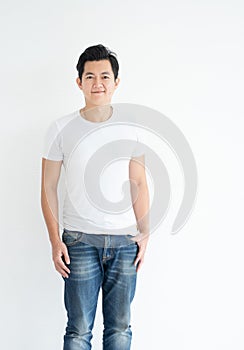 Smiling handsome Asian man in casual white t-shirt with jeans looking at camera studio shot isolated on white background