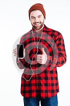 Smiling handsome berded man holding mobilephone and showing okay gesture