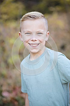 Smiling handsome boy playing outdoors and looking at the camera