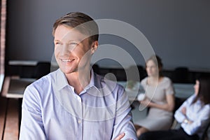 Smiling male worker thinking about future business success