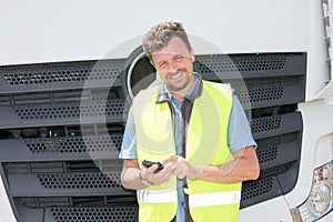 smiling handsome delivery man driver truck looking his smartphone app for deliver