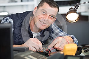smiling handsome electrician checking electrical system