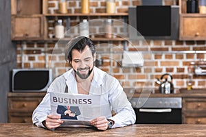 smiling handsome loner businessman reading newspaper