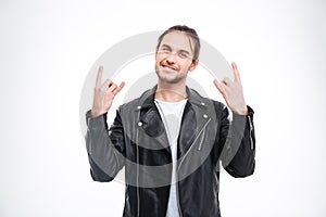 Smiling handsome man in black leather jacket doing rock gesture