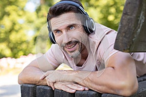 smiling handsome man in headphones listening to music