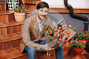 Smiling handsome man holding a bunch of roses