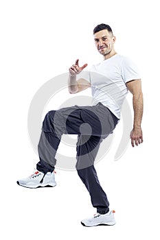 Smiling handsome man in a white tank top and dark trousers is jumping. Positivity and confidence. Full height. Isolated on white