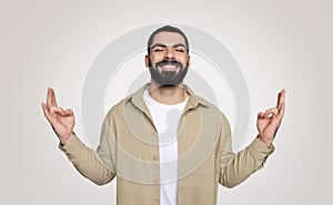 Smiling handsome young latin guy with beard with closed eyes, meditation