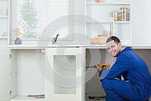 Smiling handyman fixing a door photo