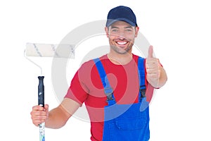 Smiling handyman with paint roller gesturing thumbs up
