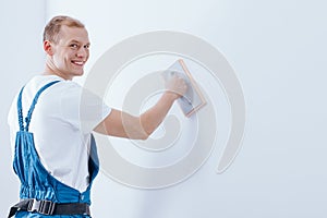 Smiling handyman priming substrate