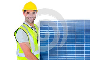 Smiling handyman in protective clothing carrying solar panel