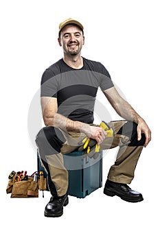Smiling handyman seated with tools