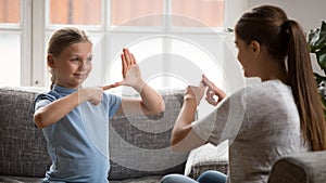 Smiling happy adorable girl communicating nonverbal with deaf dumb mother.