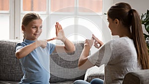 Smiling happy adorable girl communicating nonverbal with deaf dumb mother. photo