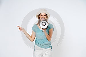 Smiling happy asian girl holding megaphone and pointing up, announcing discount promo, showing advertisement on top, standing over