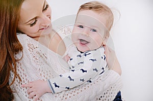 Smiling happy baby boy with his caring mother