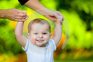 Smiling happy baby learning to walk