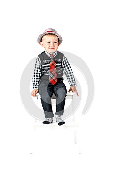 Smiling happy boy on stool studio shot isolated on a white background