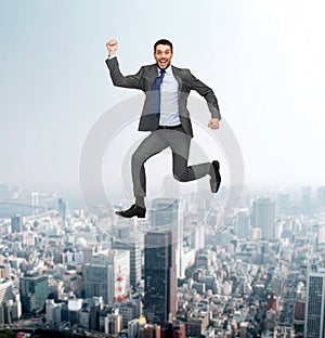 Smiling happy businessman jumping