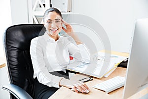 Smiling happy businesswoman sitting at the table