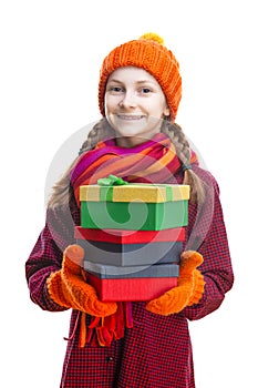 Smiling Happy Caucasian Little Girl In Orange Beanie, Scarf and Mittens With Pile of Colorful Giftboxes.