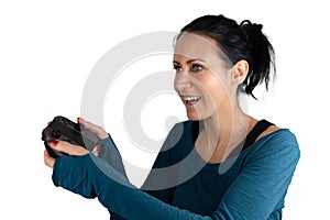 A smiling happy, concentrated young caucasian woman holding a wireless joypad excited focusing playing a digital online video game