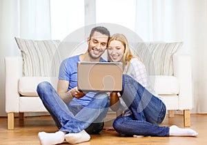 Smiling happy couple with laptop at home