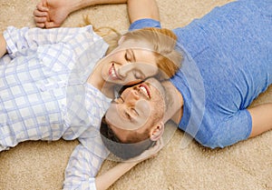 Smiling happy couple lying on floor at home