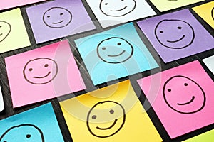 Smiling happy faces drawn on sheets. Customer Experience and evaluation concept