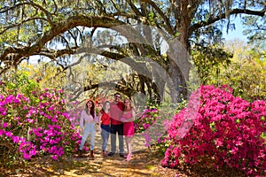 Smiling happy family enjoying time together in beautiful  blooming garden on a spring day