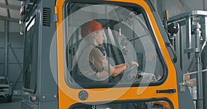 smiling happy fmale driver sitting in forklift