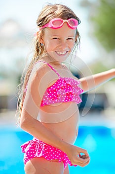 Smiling happy girl in goggles for swimming at outdoor pool