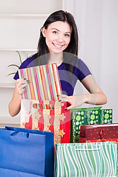 Smiling happy girl prepares bags gifts for Christmas