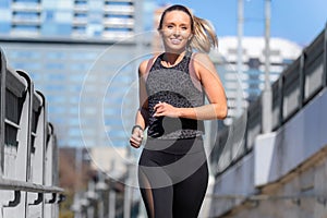 Smiling happy and healthy lifestyle active portrait jogging through downtown urban cityscape in downtown austin texas