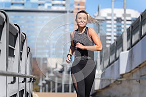 Smiling happy and healthy lifestyle active portrait jogging through downtown urban cityscape in downtown austin texas