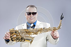 Smiling Happy Male Saxo Player in White Suit and Sunglasses Posing with Saxophone Against White Background