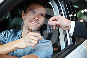 Smiling happy man sitting in his new car