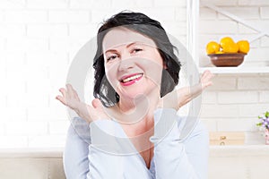 Smiling happy middle age woman with healthy natural teeth at home background. Skin care and anti aging wrinkle concept. Selective