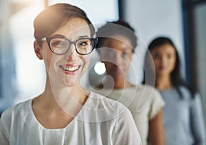 Smiling and happy modern business woman looking proud of her success and team. Portrait of a female office worker with a