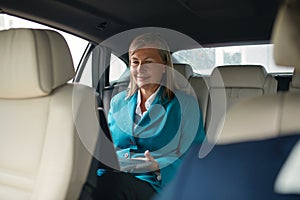 Smiling Happy Old Senior Business Woman 60-65 Years Using Laptop in Car