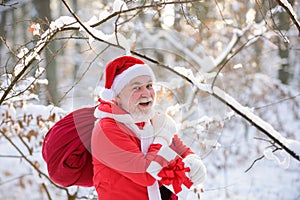 Smiling happy Santa with Gift on Christmas Eve outside. Postcard, greeting card.