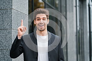 Smiling happy student man showing eureka gesture. Portrait of young thinking pondering businessman having idea moment