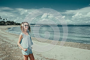 Smiling happy tourist woman enjoy vacation on Kuta beach. Bali traveller. Explore beautiful Indonesia landscape. People travel.