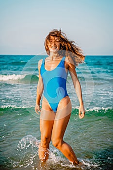 Smiling, happy woman in bikini playful on paradise tropical beach with ocean.