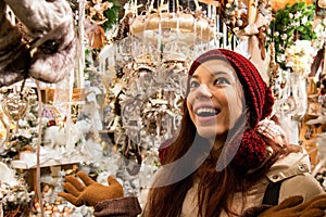 Smiling happy woman in front of display window shopping Christmas tree decorations