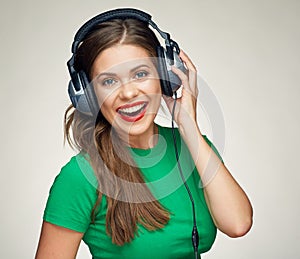 Smiling happy woman listening music with big headphones