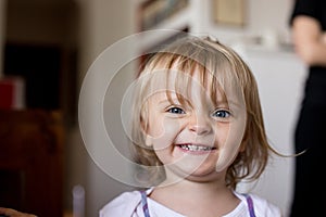 Smiling happy young baby caucasian blonde girl portrait at home