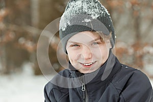 Smiling happy young boy covered in snow